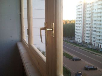 Светлые деревянные окна на балконе
